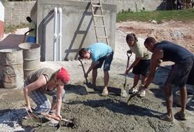 Building Building volunteers in Jamaica mix cement during the construction of a new house.