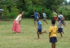 Fiji A childcare volunteer plays a game with local children in Fiji to help with improving their motor skills.