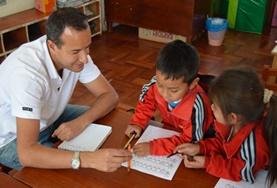 Care A volunteer provides support for children as they finish their homework at one of our childcare placements at a school in Peru.