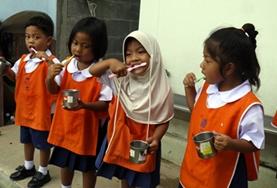 Care Local children learn how to brush their teeth correctly under the guidance of one of our childcare volunteers in Thailand.