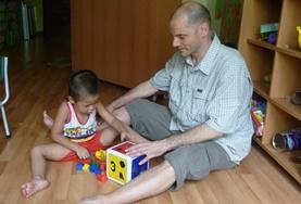 Care A Care volunteer works with a child in Vietnam, playing an educational game.