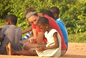 Ghana An adult volunteer works on a child's reading skills at a care centre during our Care & Community project in Ghana.