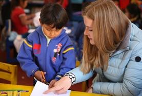 Care A childcare volunteer guides a child through his homework at our Care & Community placement in Peru.