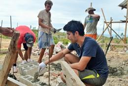 Building A High School Project volunteer helps with building the framework for a house in the Philippines.