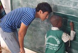 Care A high school student teaches a child how to write on a blackboard at his volunteer placement at a school in Senegal.
