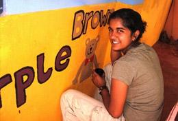 Care A High School Project volunteer paints an educational mural at a school as part of her Care & Community work in Sri Lanka.