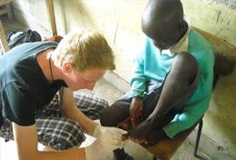 Medicine & Healthcare A high school student volunteering in Kenya helps with disinfecting a child's wound at a Medicine community outreach.