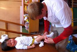 Peru A high school student volunteering at our Medicine placement in Peru assists with dressing a baby.