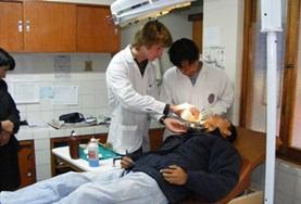 Medicine & Healthcare A Dentistry volunteer assists while a dentist examines a patient's teeth at a hospital in Peru.