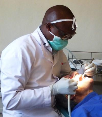 A dentistry volunteer helps clean a man’s teeth in Kenya. A dentistry volunteer performs a routine check-up in Kenya.