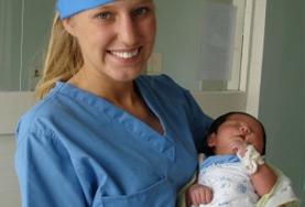 Medicine & Healthcare A Midwifery intern volunteering in the maternity department of a Mongolian hospital holds a newborn baby.