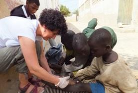 Senegal A Nursing volunteer assists local medical staff with dressing children's wounds at our medical placement in Senegal.