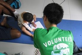 Medicine & Healthcare Under the guidance of a qualified occupational therapist, a medicine volunteer in the Philippines administers a test to determine the tasks that a disabled child is struggling with.