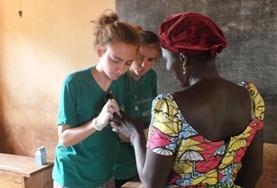 Medicine & Healthcare A Public Health intern assesses a local woman's wound during a medical volunteer outreach in Togo.