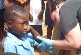 Nursing A Nursing volunteer cleans a child's wound as part of her medical internship abroad.