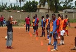 Sports A volunteer works with a local soccer team in Togo, leading them through a drill to improve their ball skills and technique.