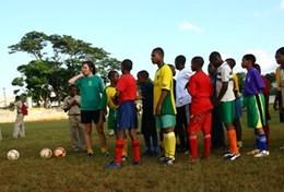 Sports A volunteer coaches students through a soccer drill during a school sports lesson in Jamaica.