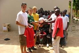 Football Soccer volunteers work together with local coaches to help children from developing countries to improve their soccer skills.