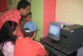 Morocco School students and volunteers gather around a computer in preparation for a lesson on our volunteer Teach IT project in Morocco.