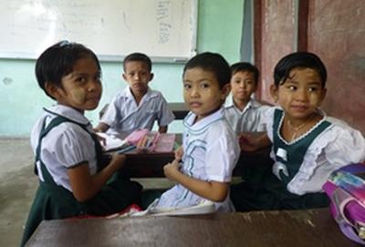 Myanmar School children sit at their desk together during an English lesson at our volunteer Teaching placement in Myanmar.