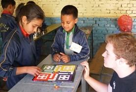 Nepal A Teaching volunteer uses a board game to teach school children about colours and numbers at a local school in Nepal.