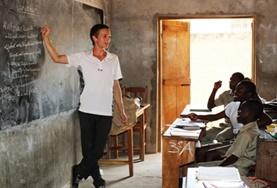 Togo A Teaching volunteer demonstrates a lesson on a blackboard to a class of school students in Togo.